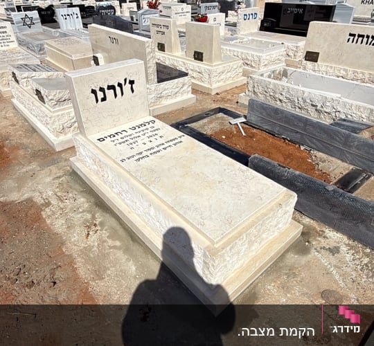 מצבת שיש ואבן עם כיתוב חרות בבית עלמין